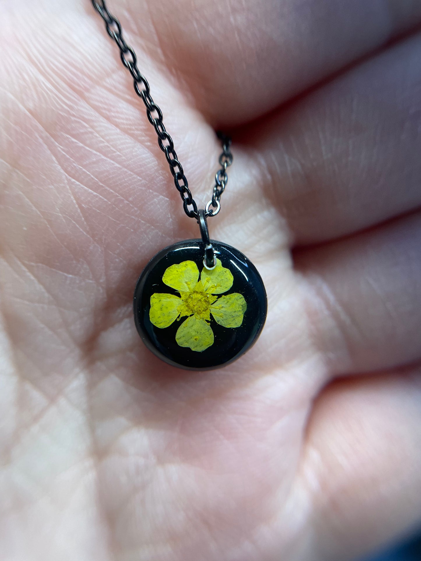 Collier petit rond fleur bouton-d’or jaune sur fond noir
