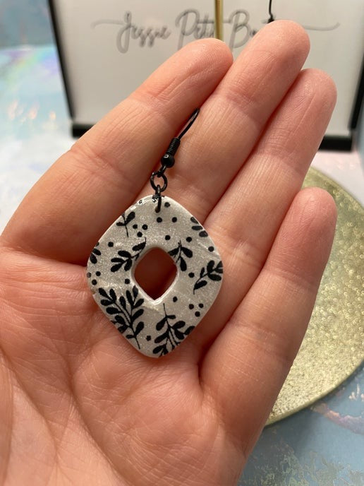 Boucles d'oreilles à fleurs noires sur argile blanche