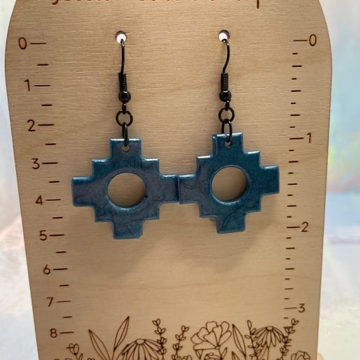 Blue geometric earrings on a wooden stand with measurements