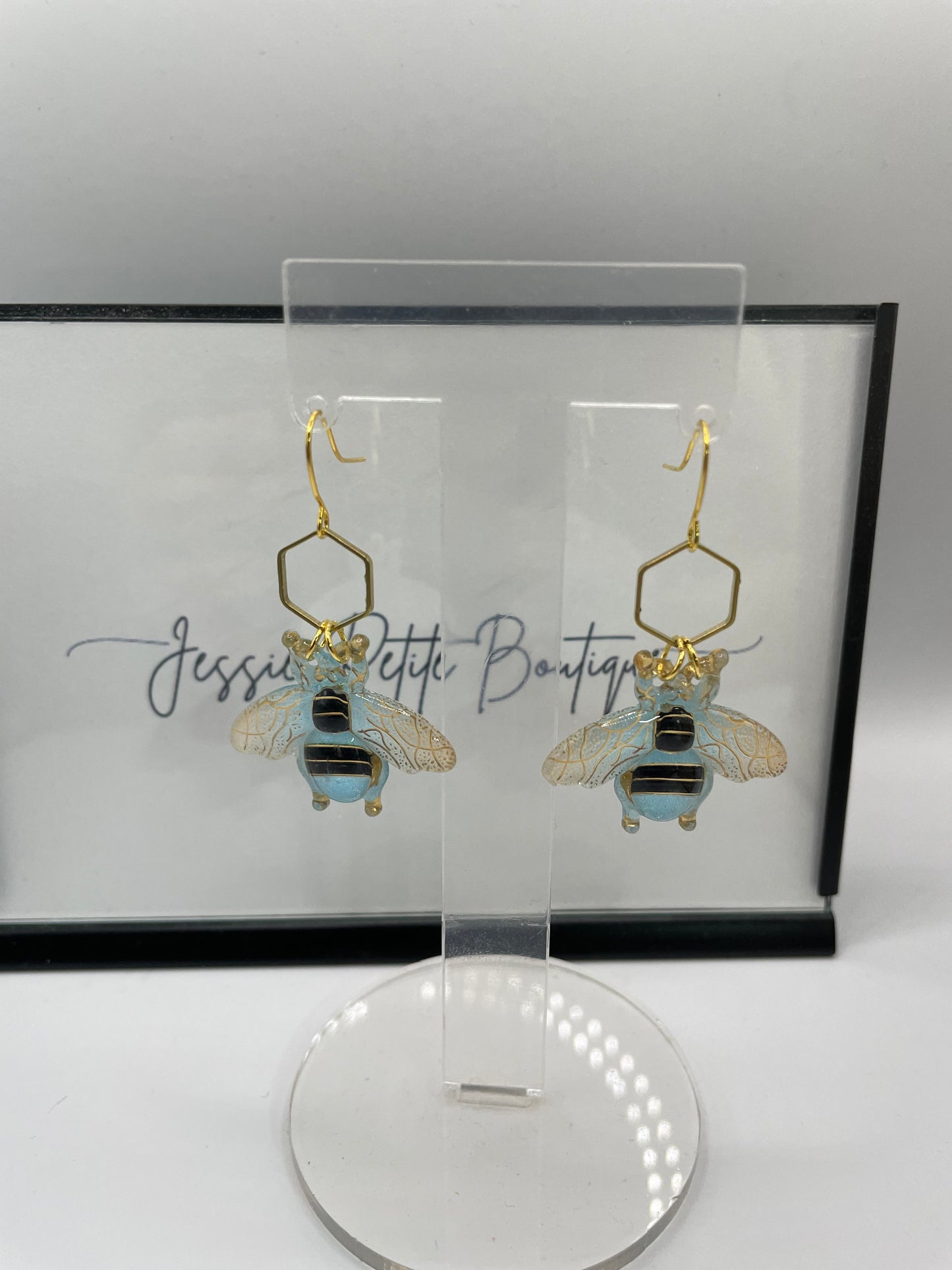  bee-themed earrings on a white background