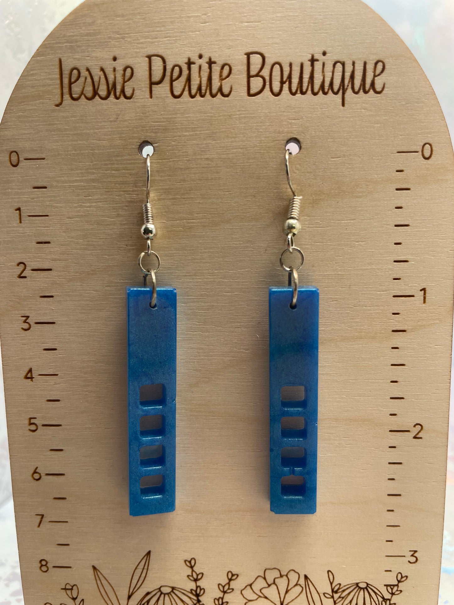 Blue earrings on a wooden card with measurements and 'Jessie Petite Boutique' branding.