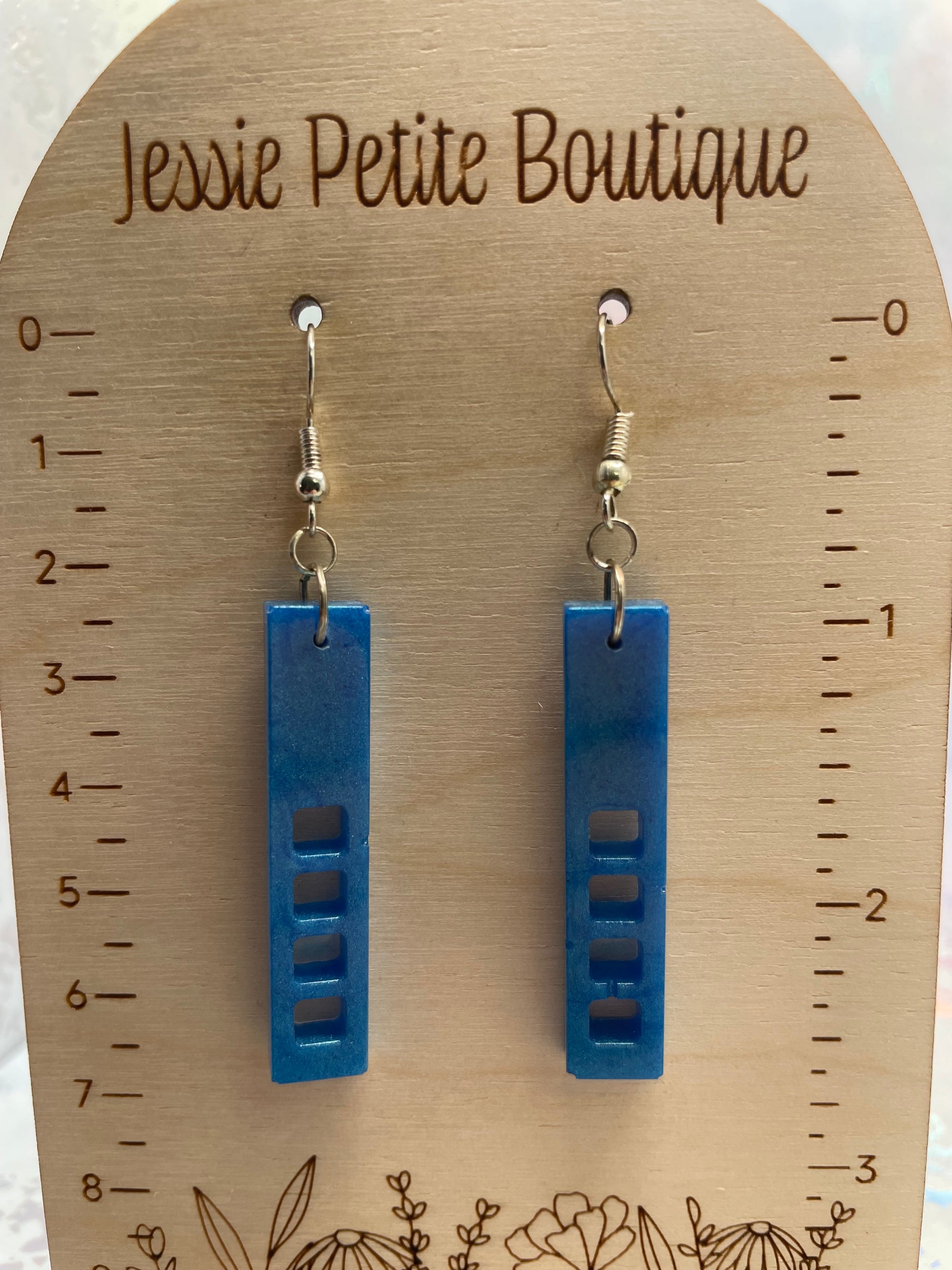 Blue earrings on a wooden card with measurements and 'Jessie Petite Boutique' branding.