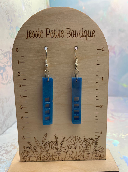 Blue earrings on a wooden card with 'Jessie Petite Boutique' branding.