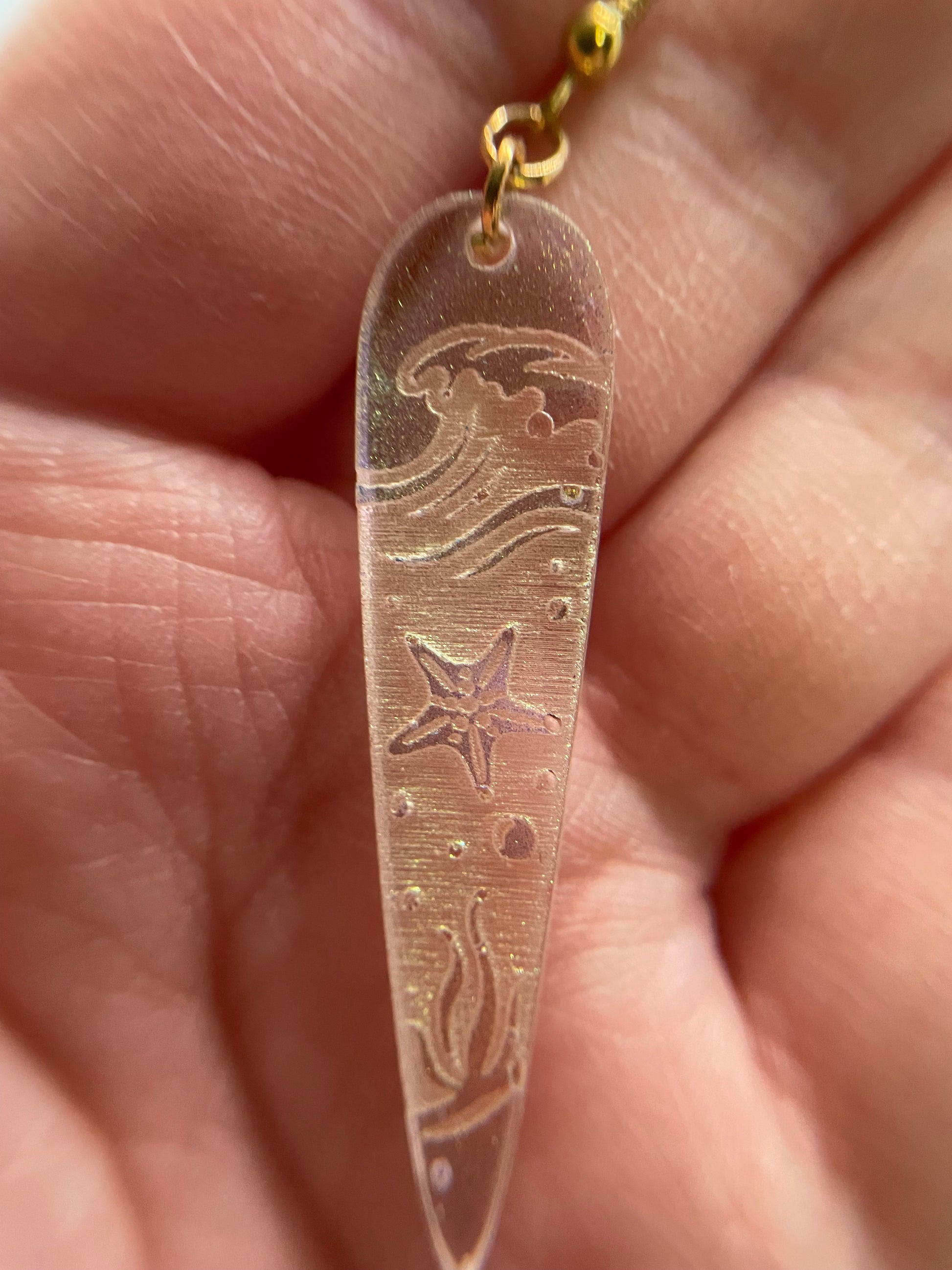 chameleon olive Ocean Wave Engraving: Earrings held between fingers