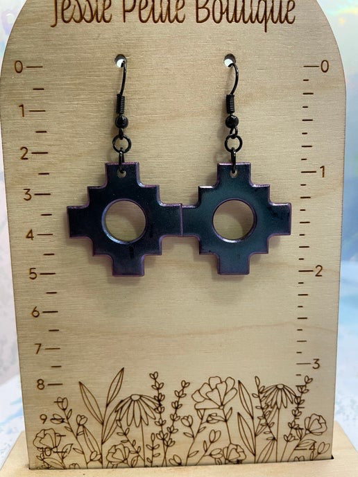 Pair of earrings on a wooden display card with floral design