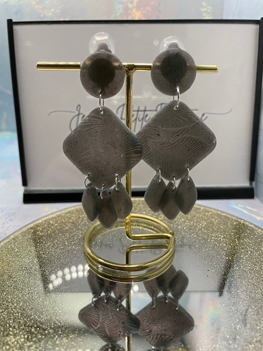 Pair of earrings on a gold stand with a blurred background