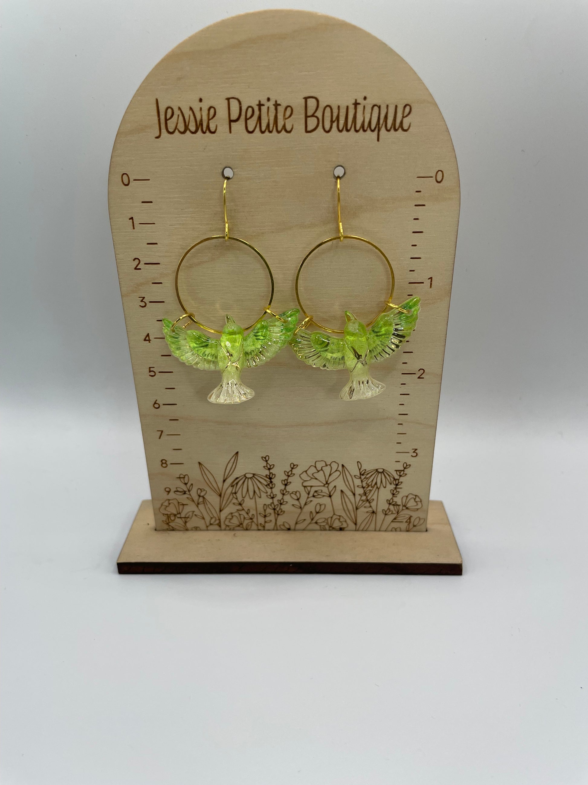 Green birds earrings on a wooden display card with 'Jessie Petite Boutique' branding.