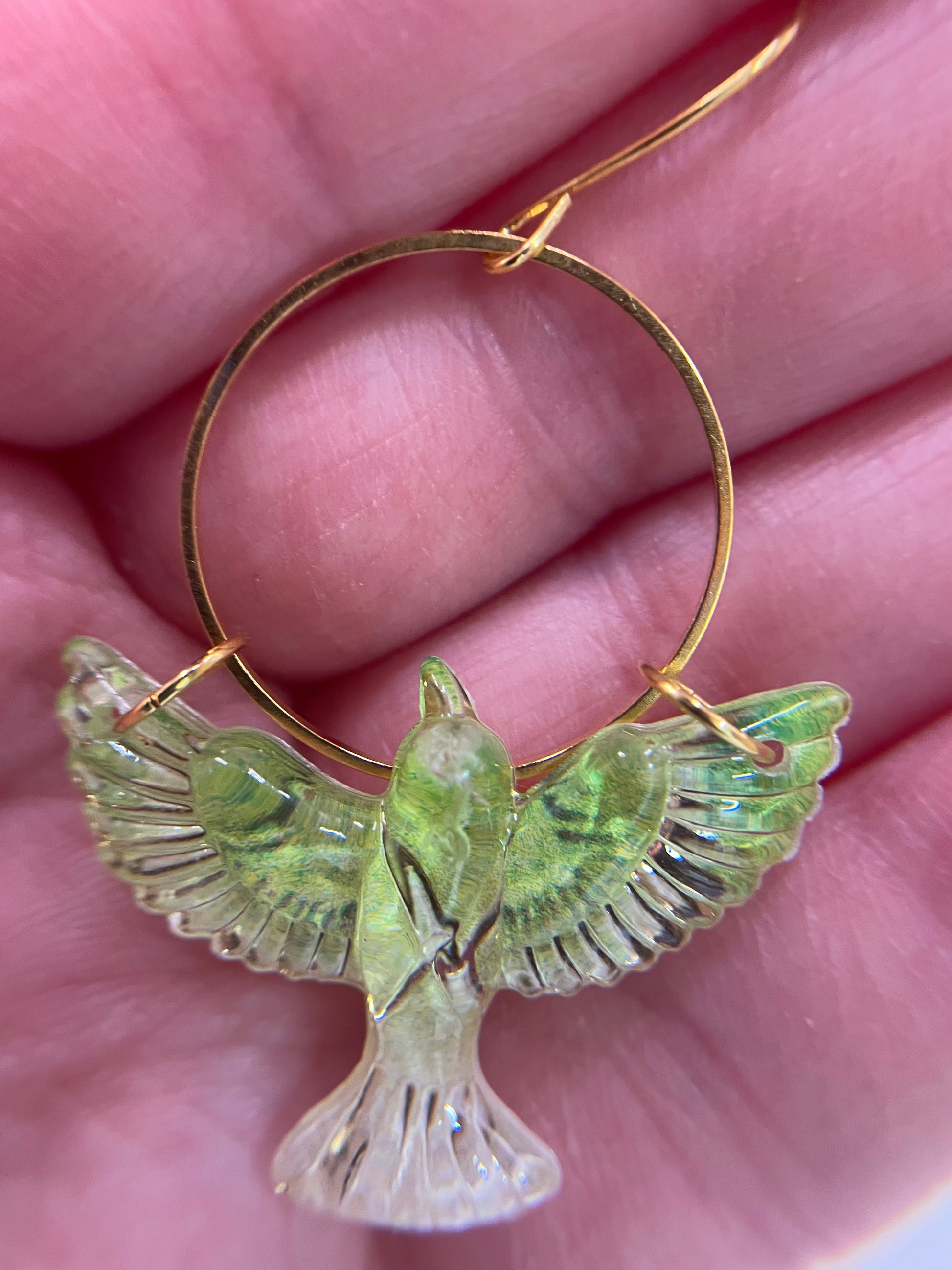 Gold hoop earring with a green bird-