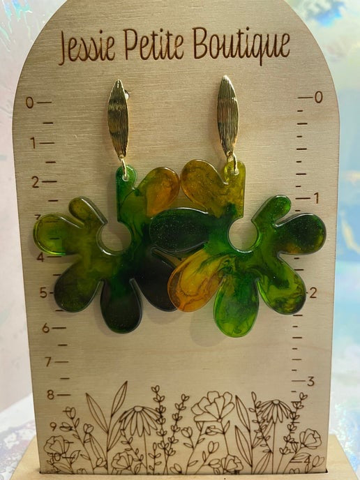 Floral-shaped earrings on a wooden display card with 'Jessie Petite Boutique' branding.