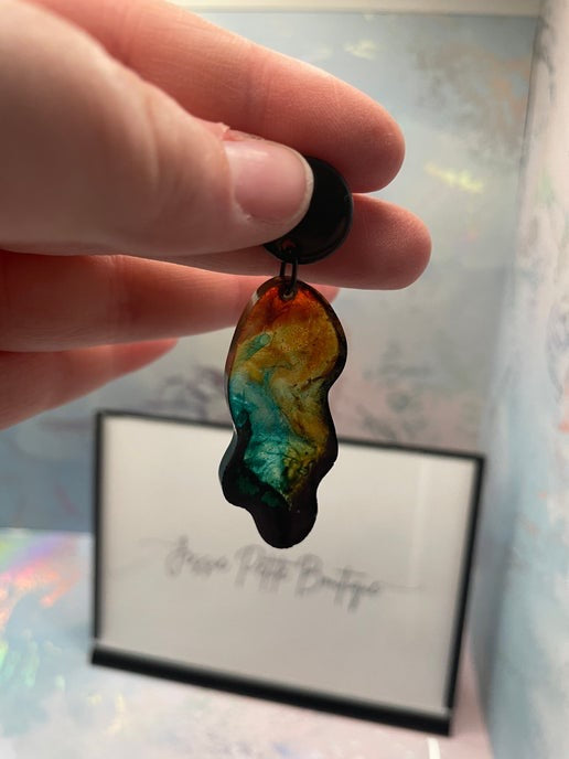Hand holding a multicolored pendant with a blurred background