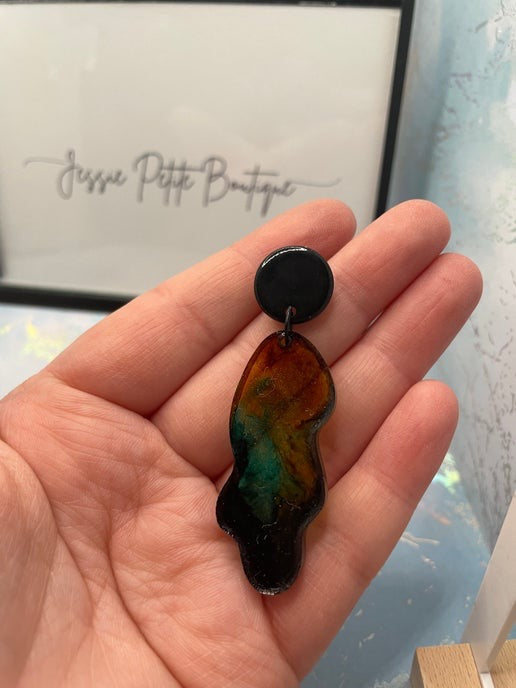 green, yellow, blue-shayna earringsheld in a hand with 'Jesse Petite Boutique' in the background.