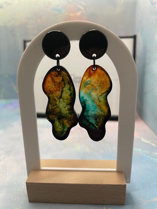 Pair of earrings on a display stand with a blurred background