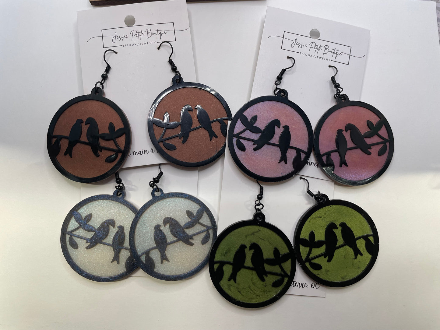 Set of earrings with bird design on a white background