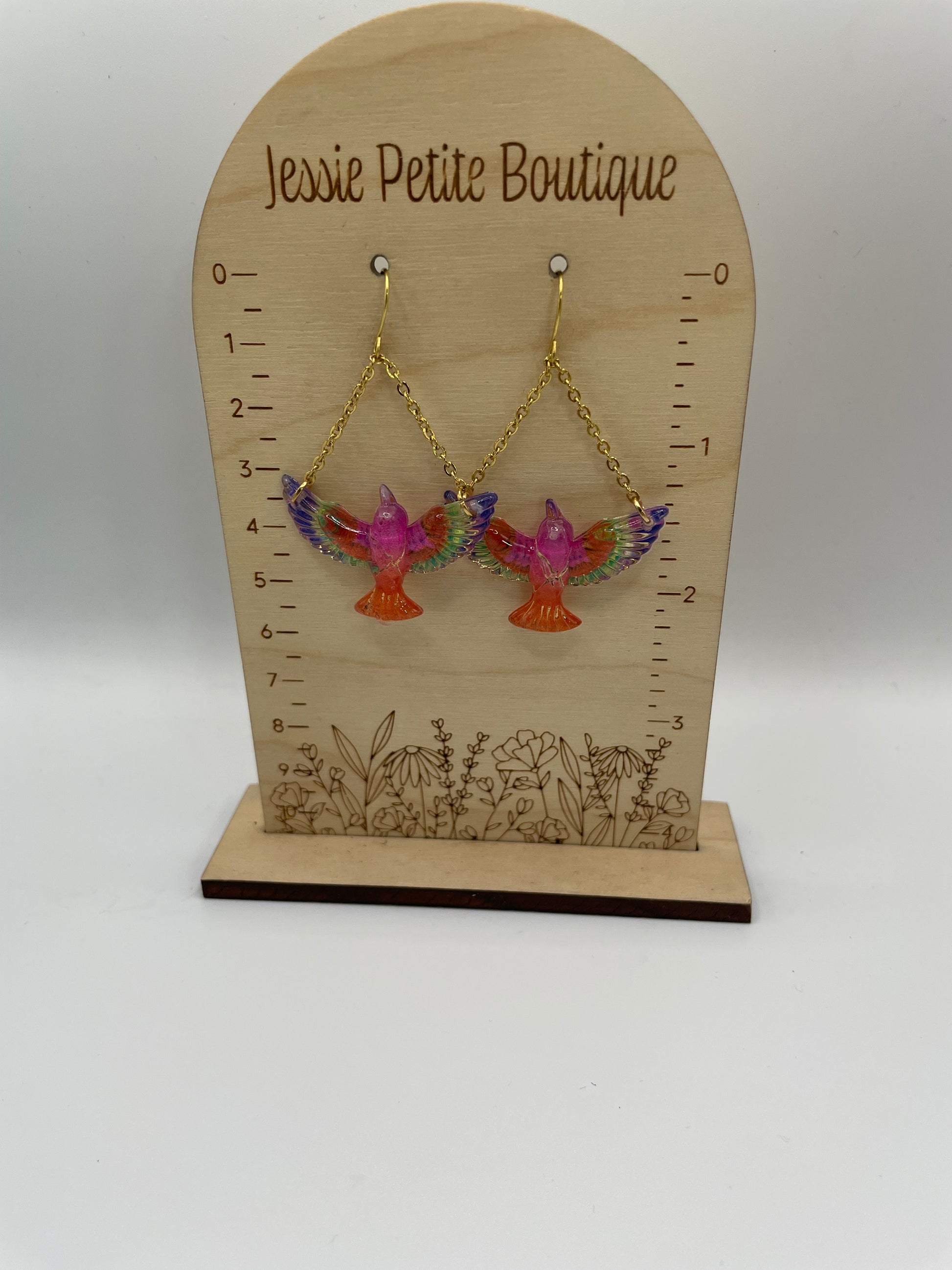Jewelry card with colorful bird-shaped earrings on a white background