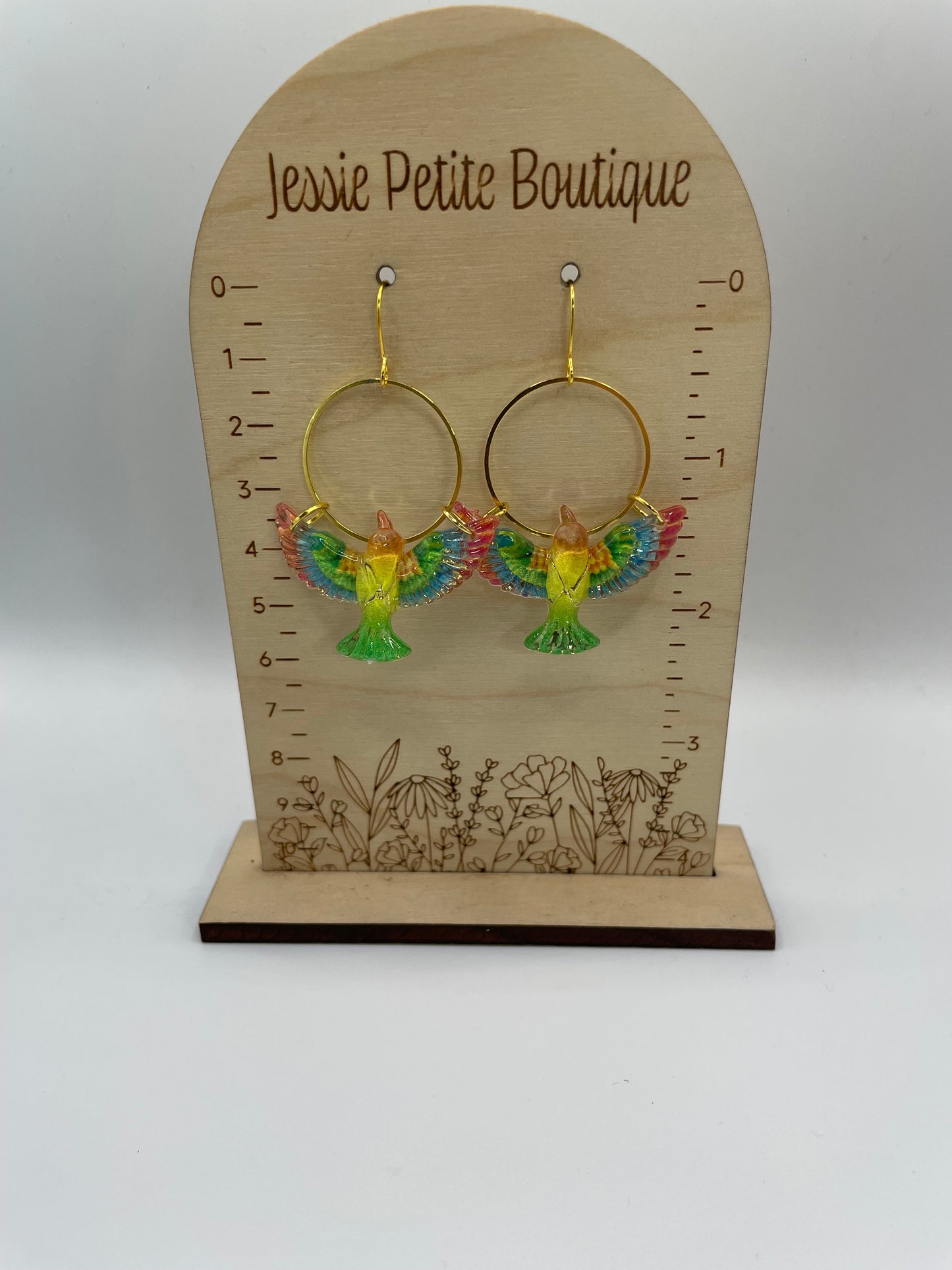 Jewelry display card with colorful earrings on a white background