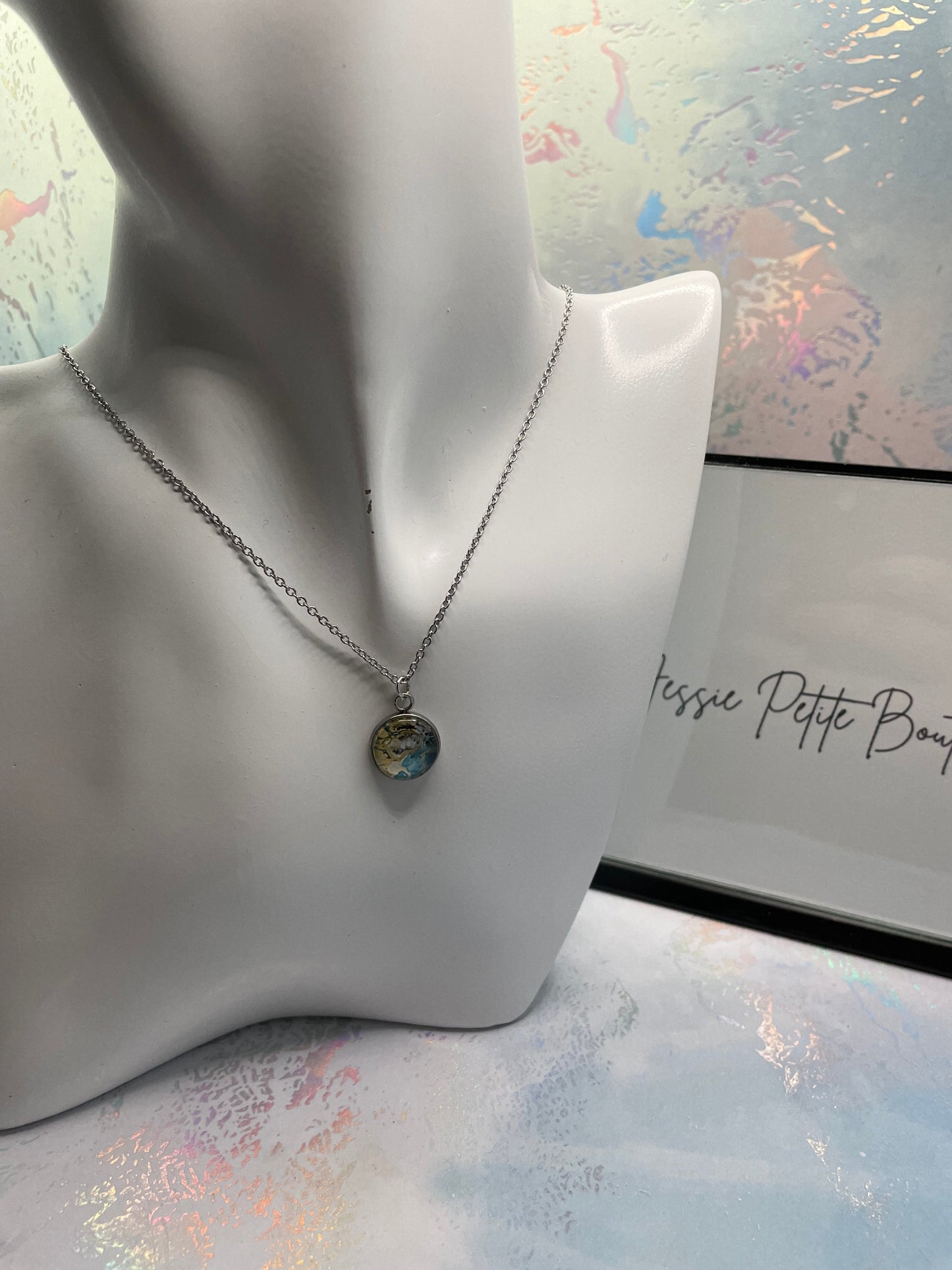 Necklace with a pendant on a mannequin bust against a decorative background