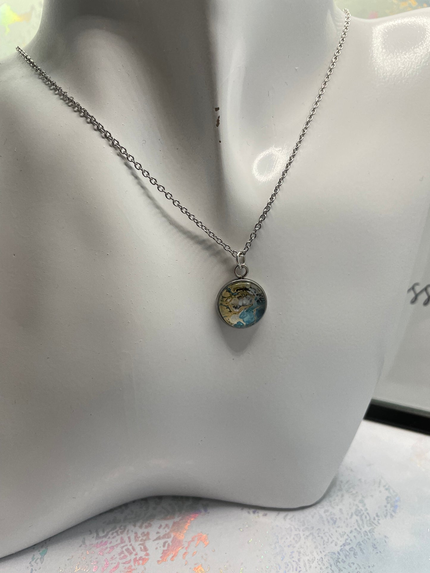 Necklace with a round pendant on a mannequin bust.