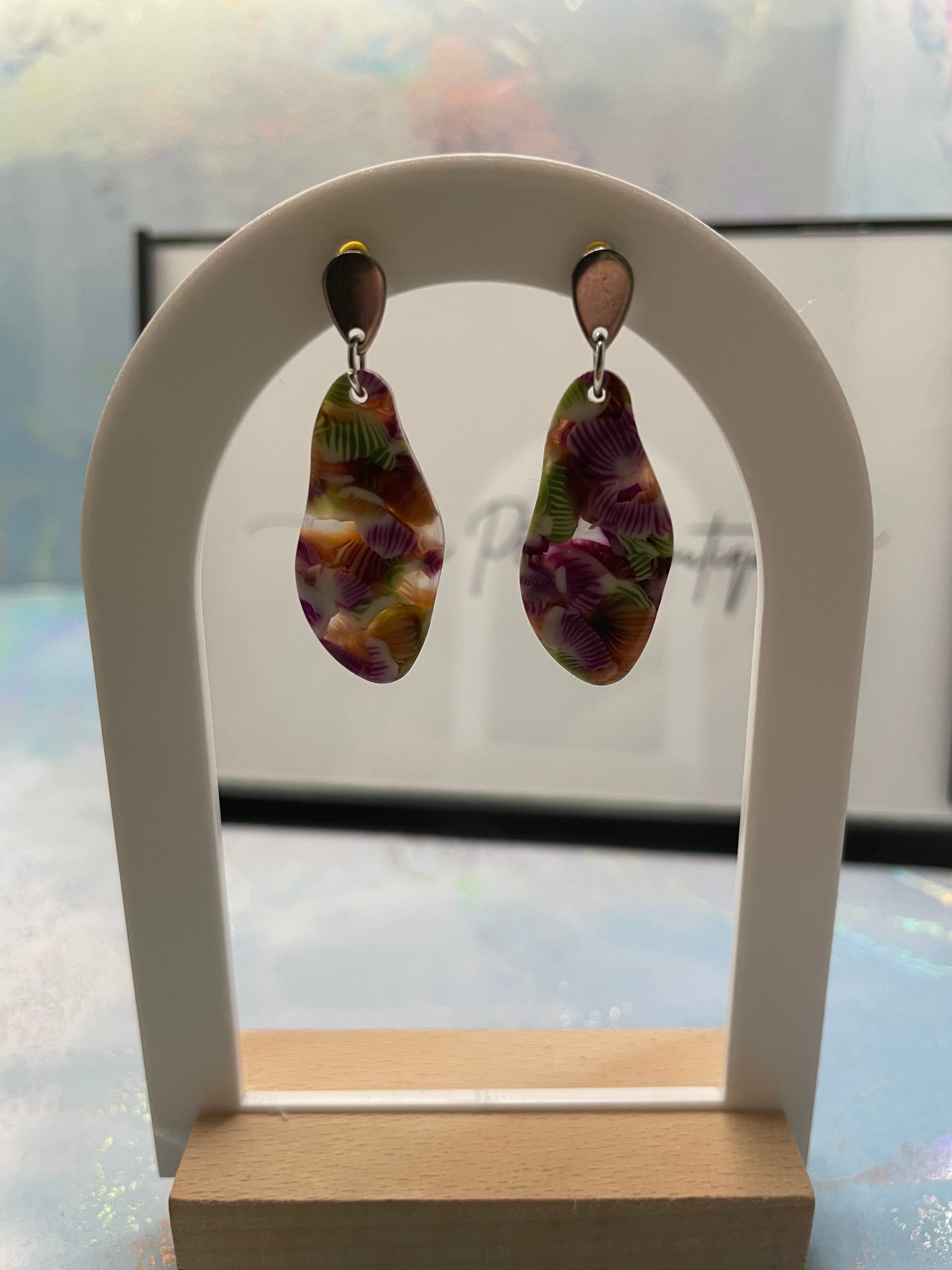 Pair of earrings on a white stand with a blurred background