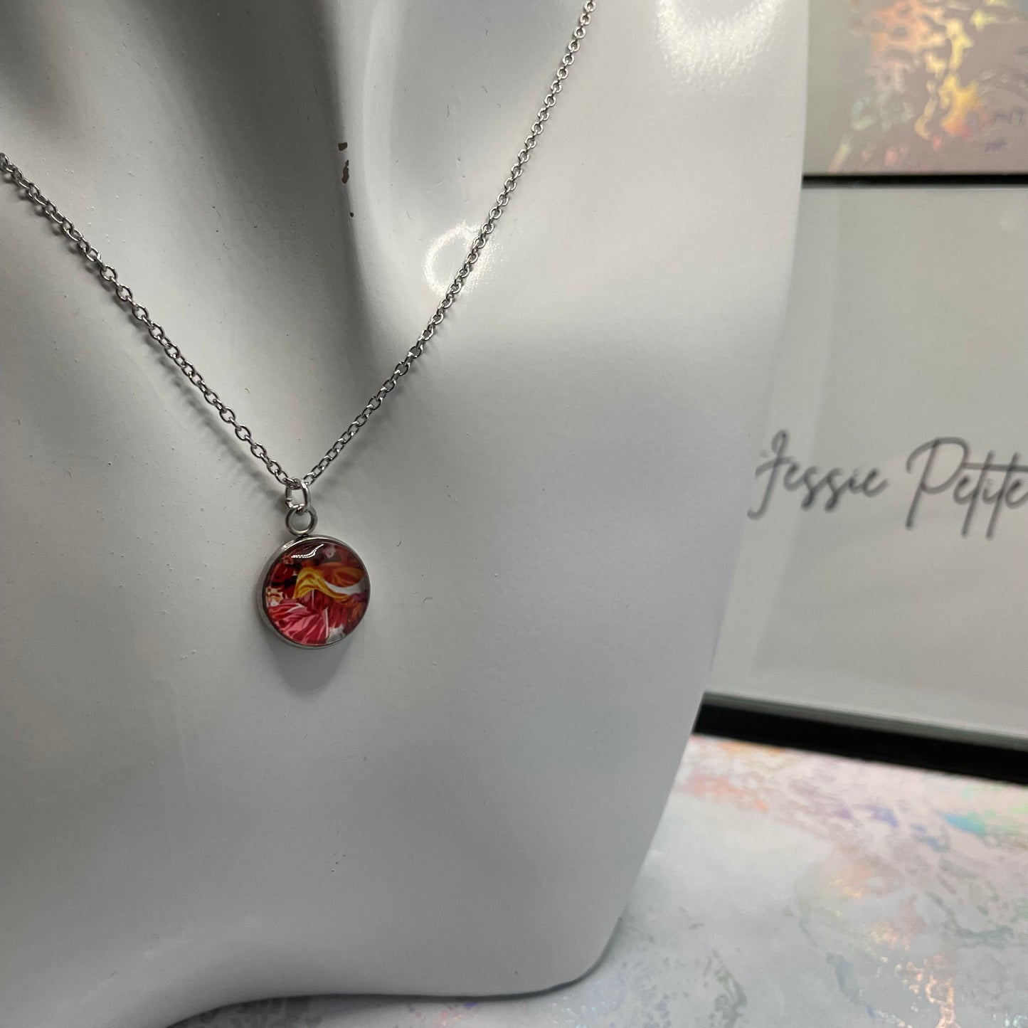 Necklace with a floral pendant on a mannequin bust, branded 'Jessie Petite Boutique'.