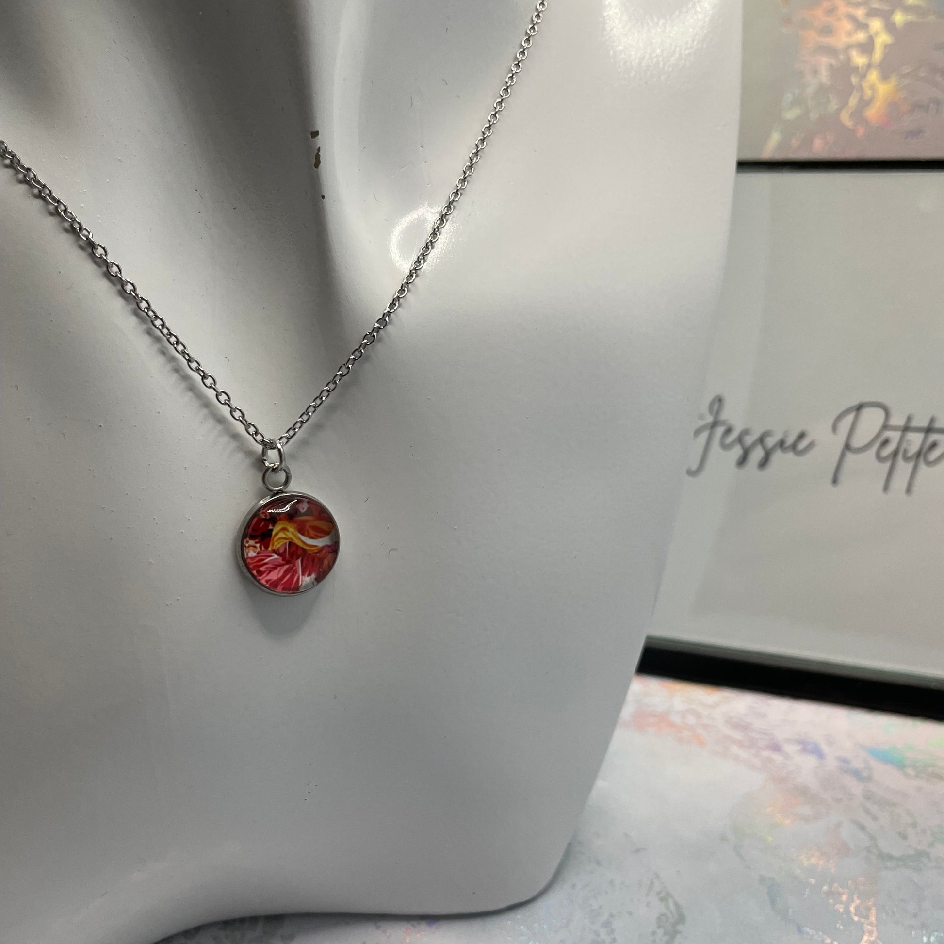 Necklace with a floral pendant on a mannequin bust, branded 'Jessie Petite Boutique'.
