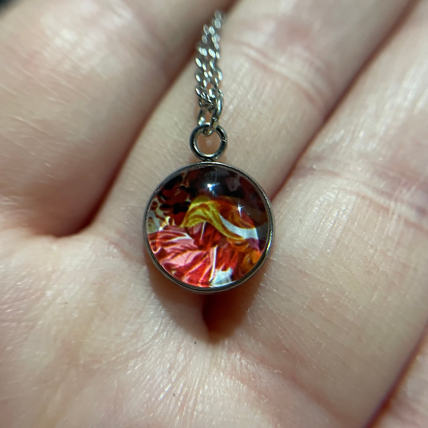 Close-up of a floral pendant necklace on a hand