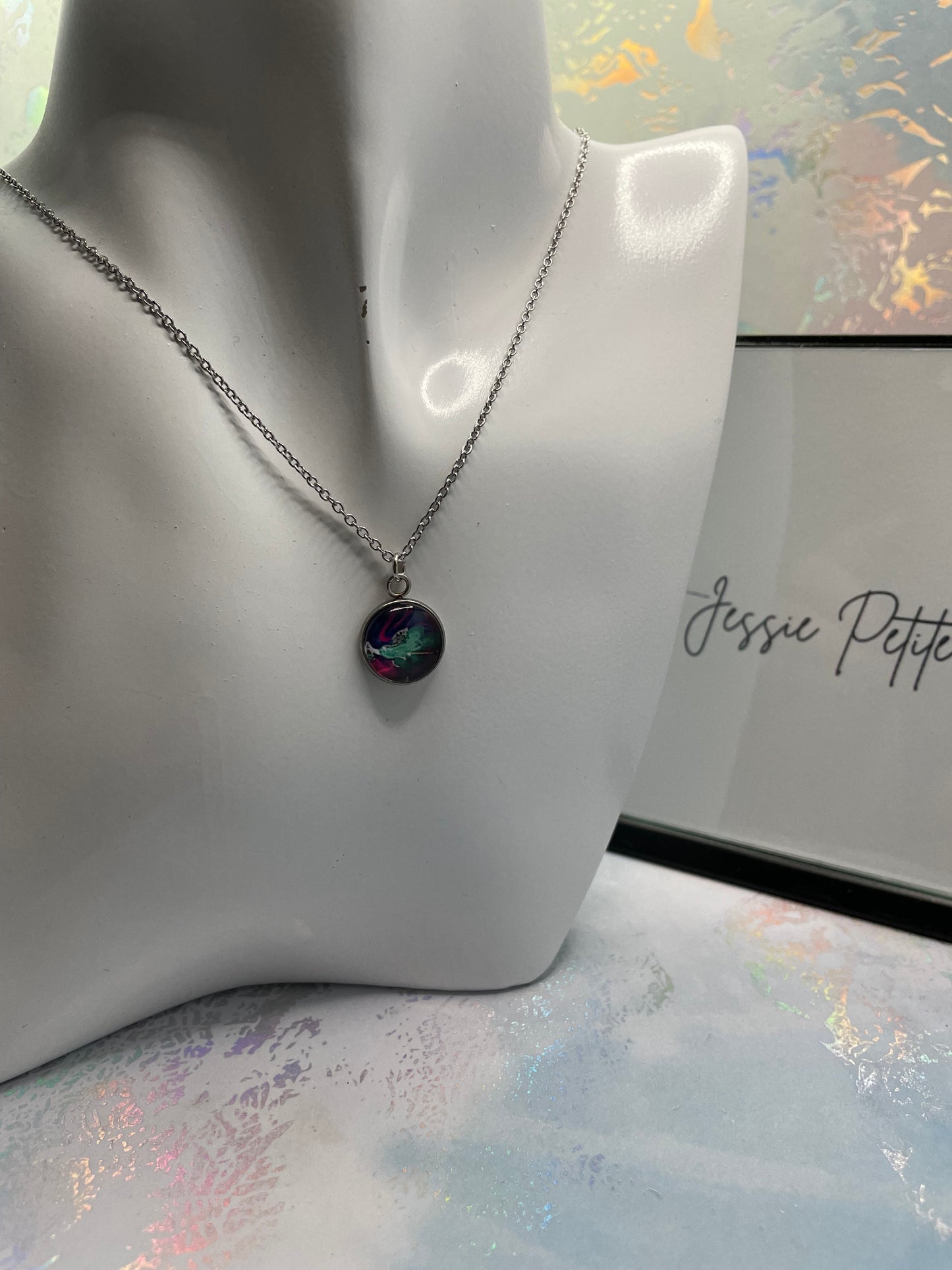 Necklace with a colorful pendant on a mannequin bust against a light background