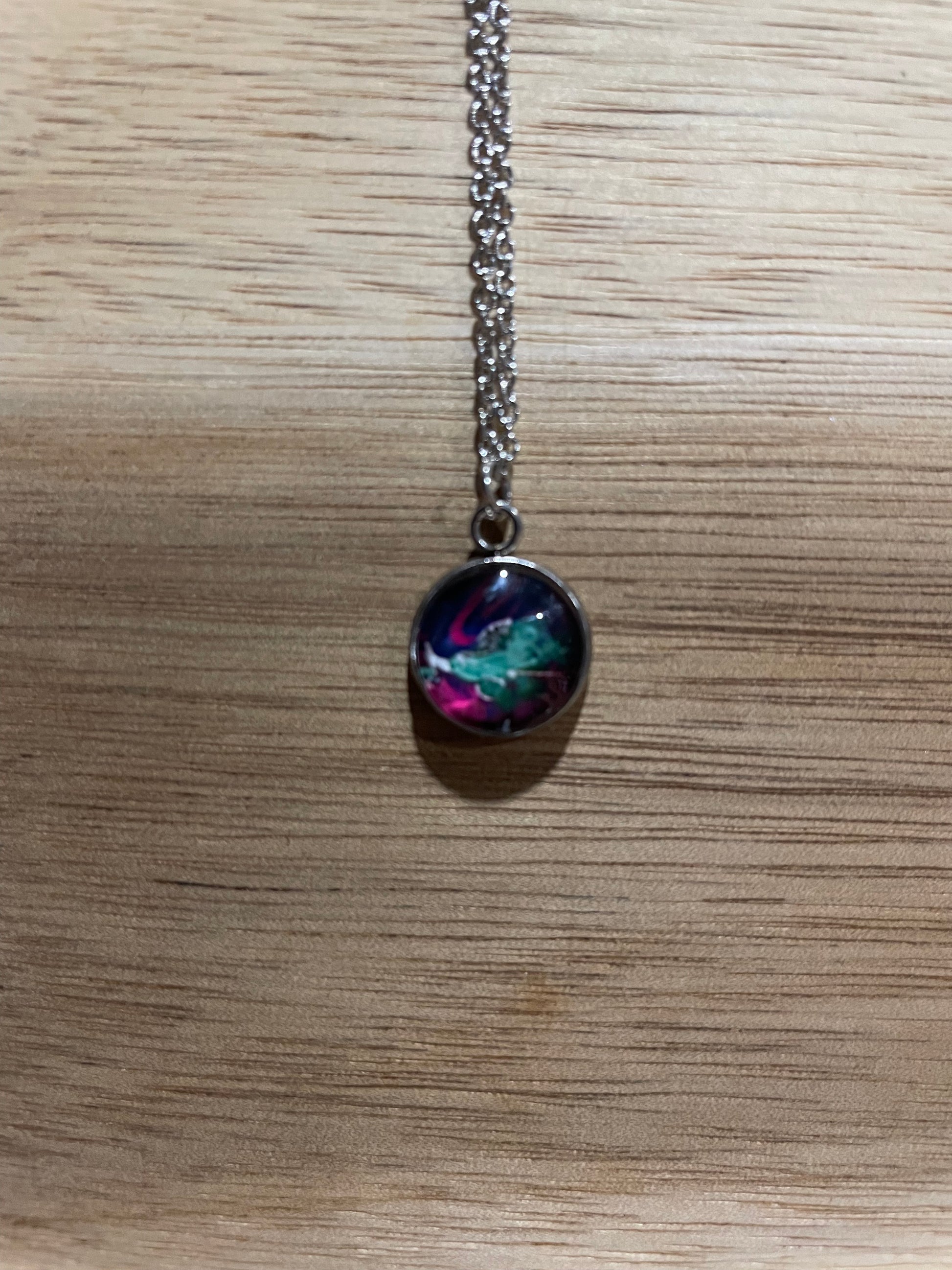 Necklace with a colorful pendant on a wooden surface