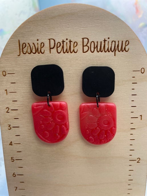 Pair of earrings on a wooden display card with 'Jessie Petite Boutique' branding.