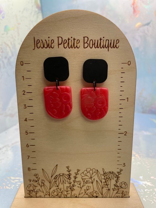 pink earrings on a wooden display card with 'Jessie Petite Boutique' branding.
