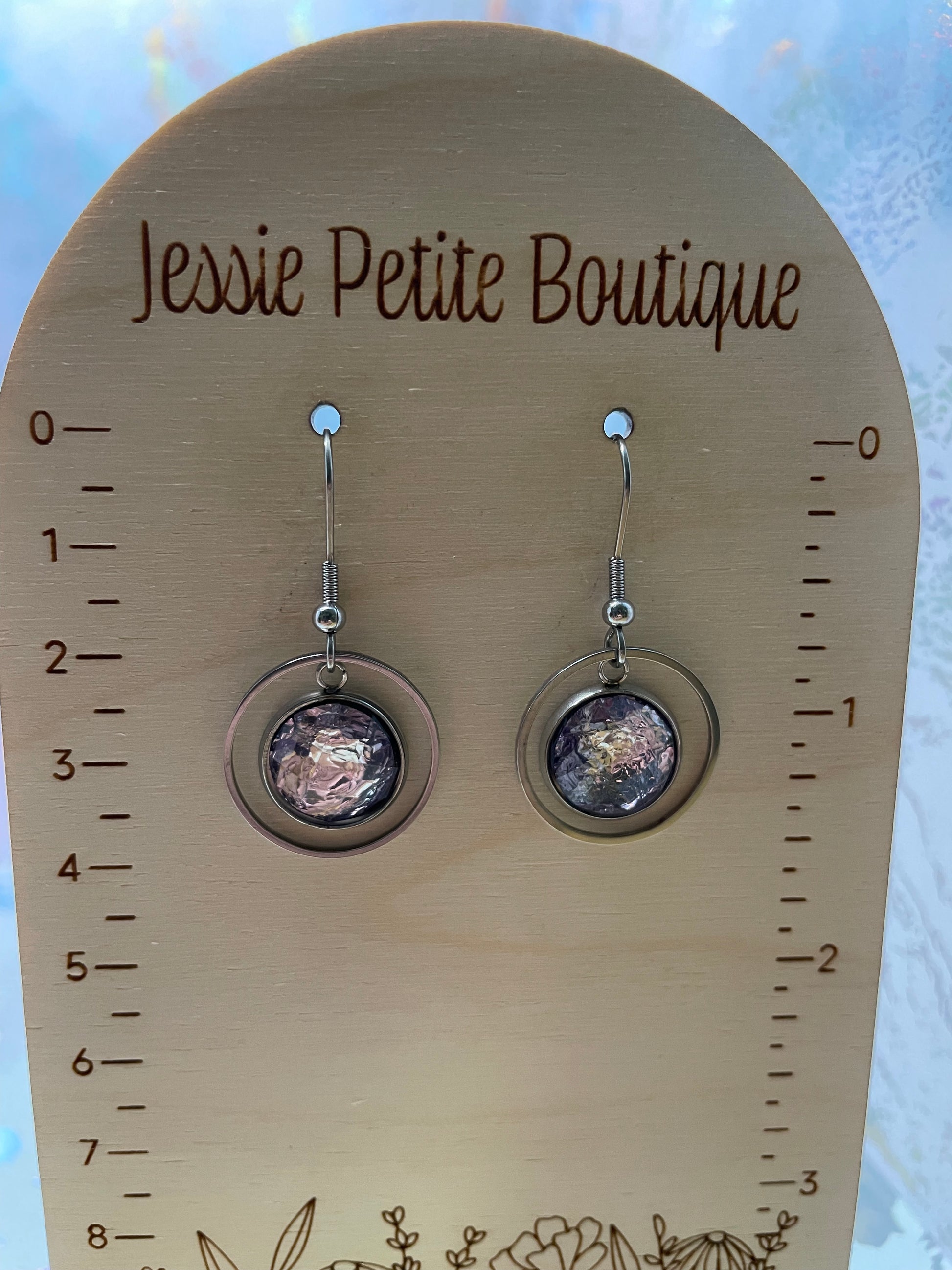 Pair of earrings on a wooden card with measurement scale and 'Jessie Petite Boutique' branding.