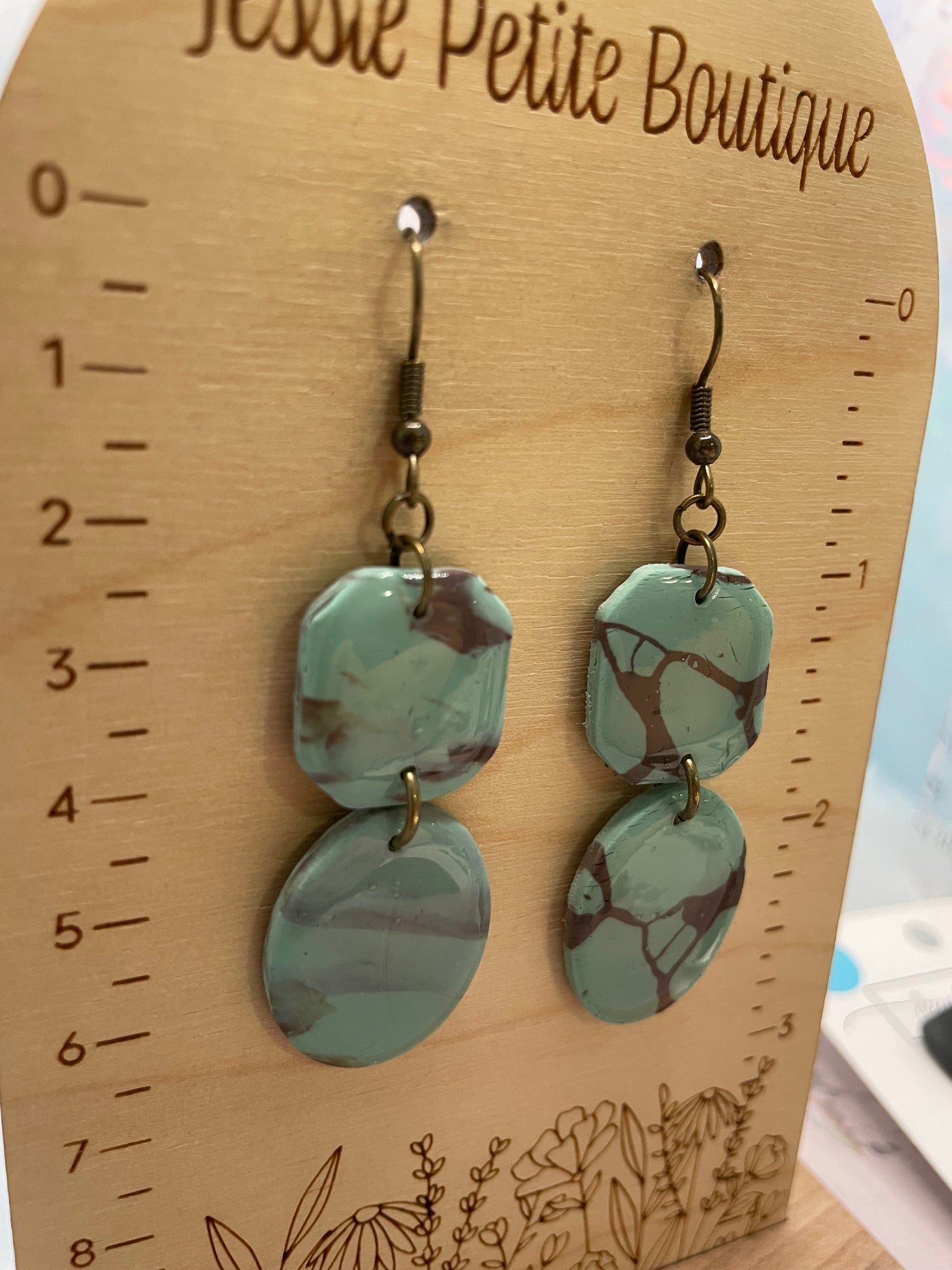 shayna earrings on a wooden measuring board with 'Jessie Petite Boutique' branding.