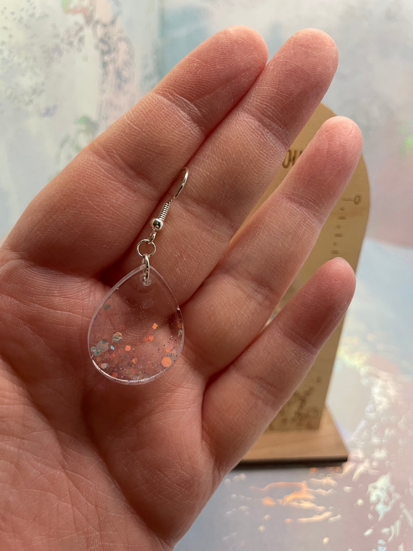 Hand holding a small-sparkly teardrop earrings