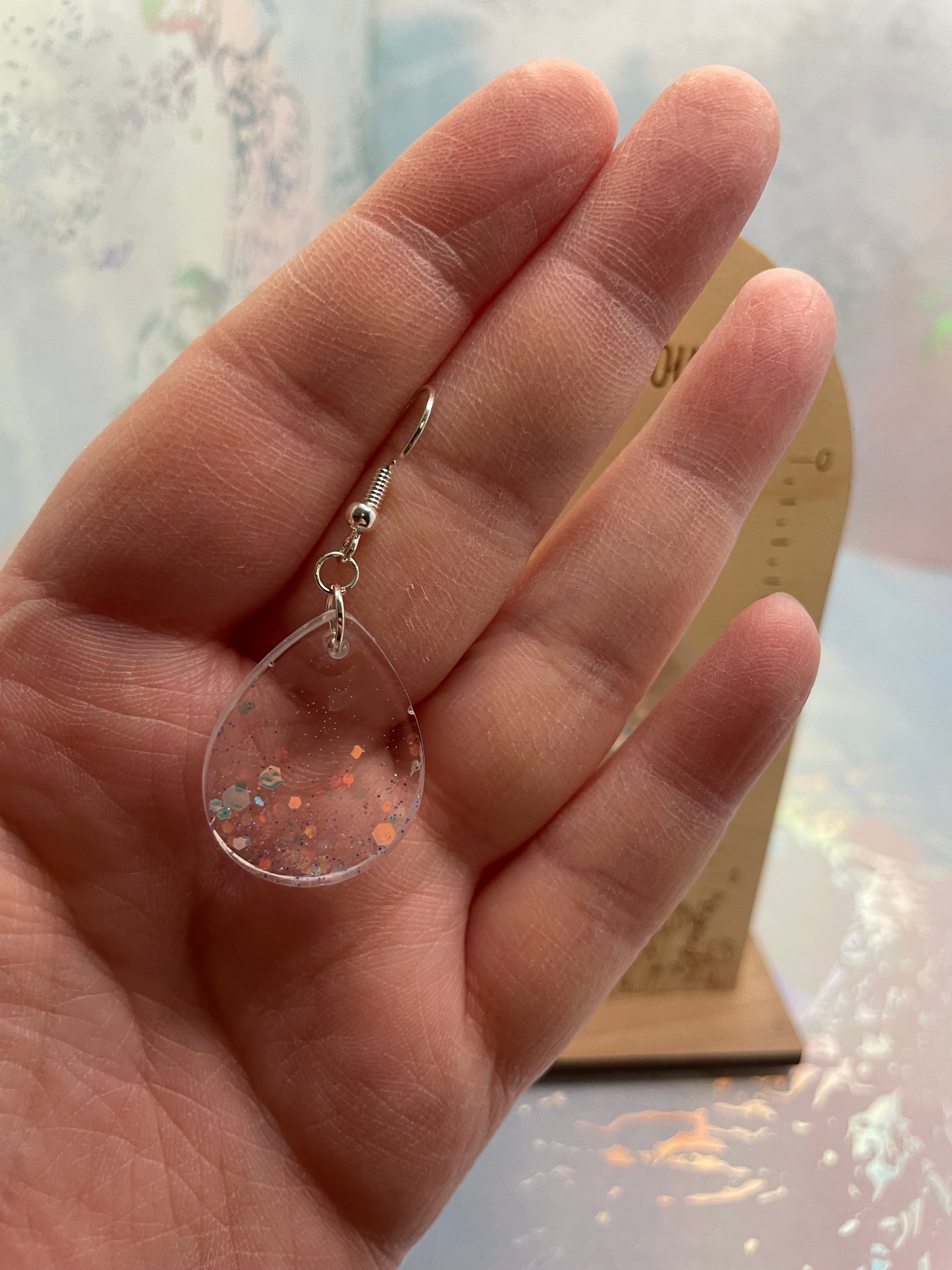 Hand holding a small-sparkly teardrop earrings