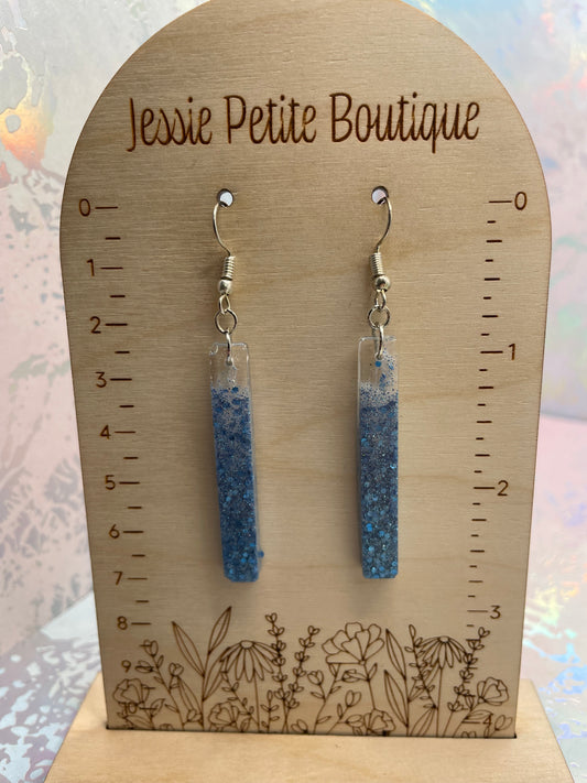 sparkly Blue earrings on a wooden card with measurements and floral design, branded 'Jessie Petite Boutique'.