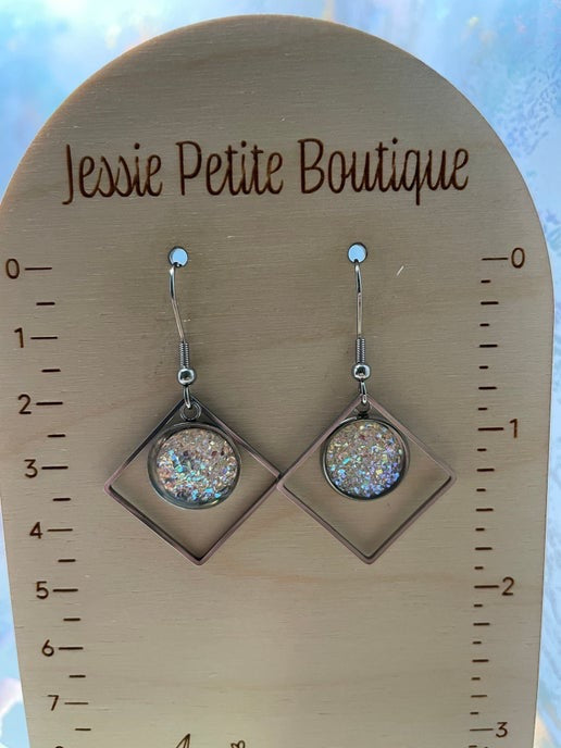 Pair of earrings on a wooden display card with 'Jessie Petite Boutique' branding.